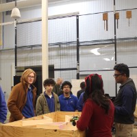 A group of students and faculty looking at a robotics project.